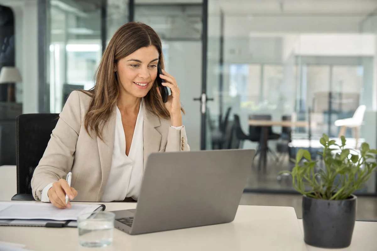 A recruiter conducts an initial phone conversation at her desk