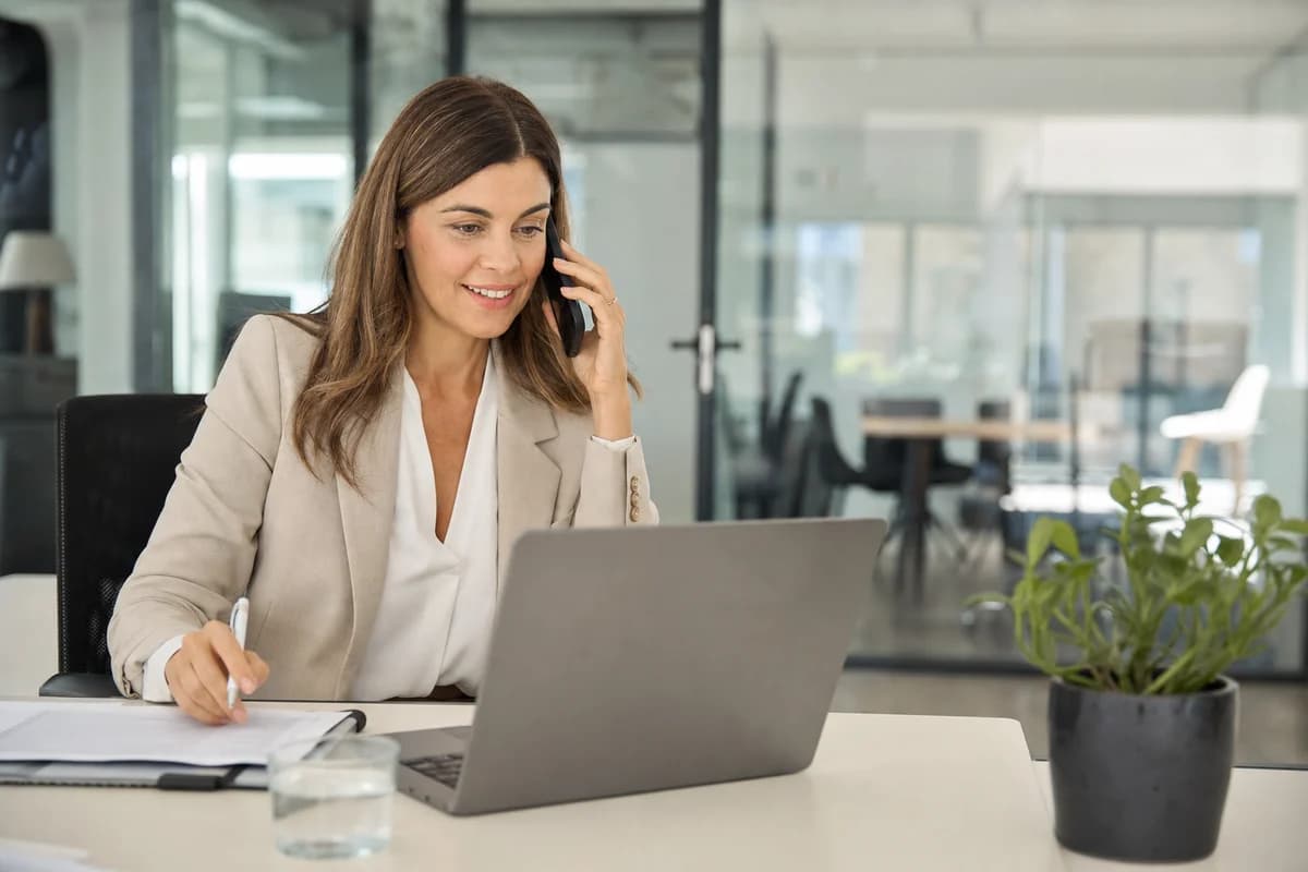 A recruiter conducts an initial phone conversation at her desk